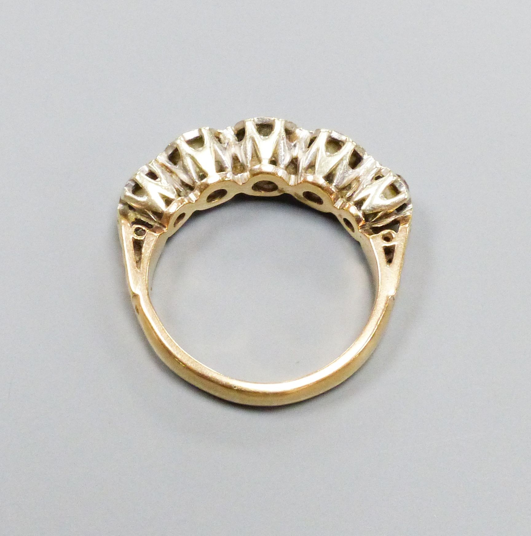 A five-stone diamond ring, 9ct white and yellow gold setting, claw-set with carved shoulders, size M, gross weight 4.3 grams.